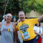 Two men pose for a picture during a race. 