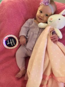 A baby holds a stuffed bunny.