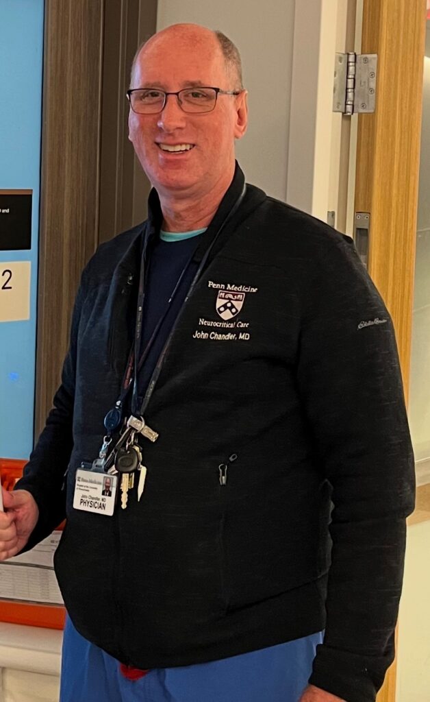 A doctor poses for a picture in a hospital.